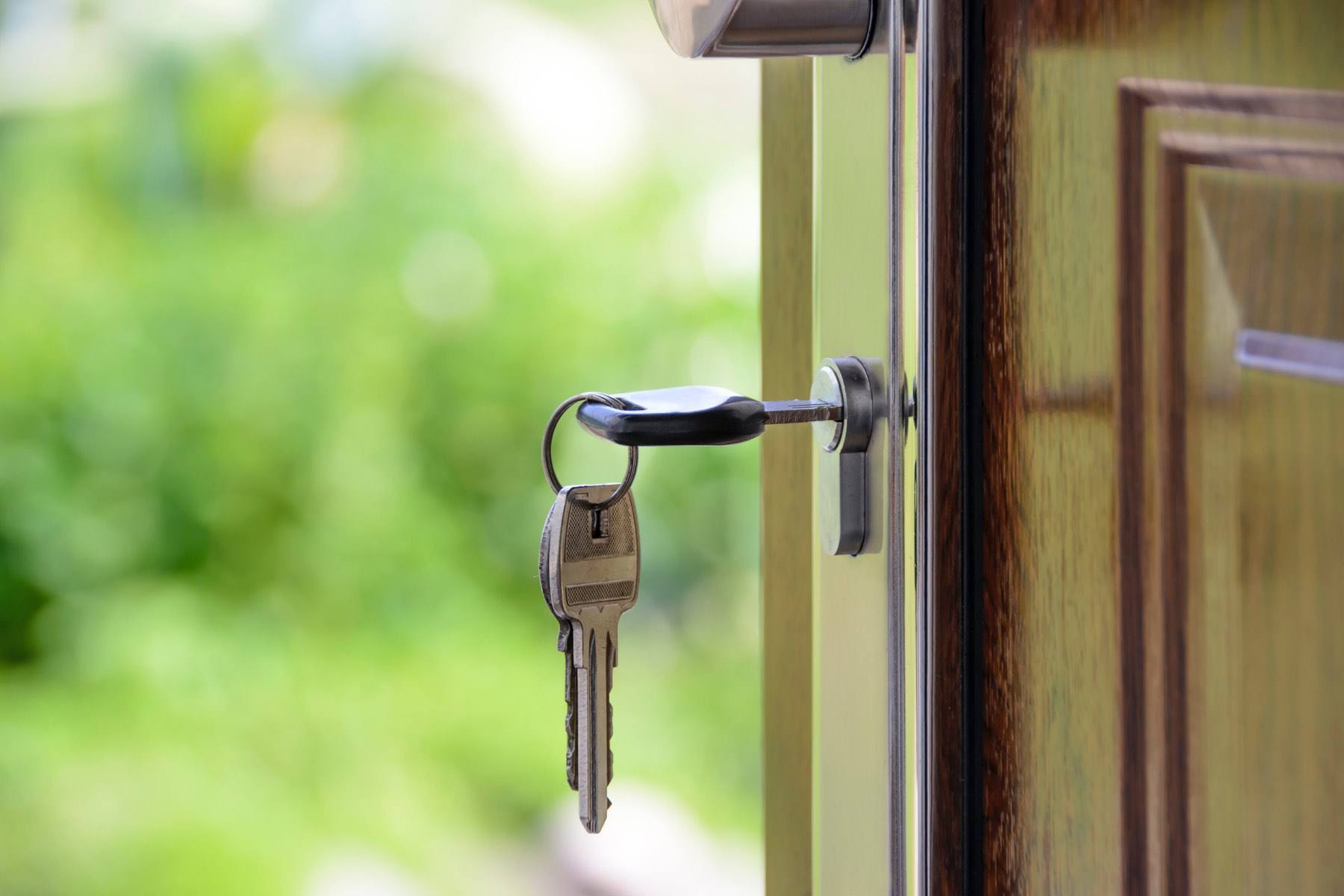 Haustürschlüssel steckt in der Tür eines Hauses